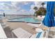 Waterfront community pool with lounge chairs and tables under umbrellas at 118 S Halifax Ave # 103, Daytona Beach, FL 32118