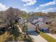 Aerial view of peach-colored residential buildings with well-maintained lawns and driveways under a bright blue sky with scattered clouds at 1187 Athlone Way, Ormond Beach, FL 32174