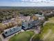 Expansive aerial view of the community clubhouse overlooking a golf course, tennis court, and parking area at 1187 Athlone Way, Ormond Beach, FL 32174