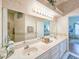 Large bathroom with dual sinks, a decorative mirror, and a view of the bedroom at 1187 Athlone Way, Ormond Beach, FL 32174
