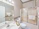 Charming bathroom with shower/tub, white vanity and sink, and patterned wallpaper at 1187 Athlone Way, Ormond Beach, FL 32174