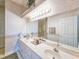 Bright bathroom featuring dual sinks, a large mirror, and decorative wallpaper at 1187 Athlone Way, Ormond Beach, FL 32174