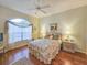 Cozy bedroom featuring a plush bed, hardwood floors, and a decorative arched window at 1187 Athlone Way, Ormond Beach, FL 32174