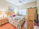 Cozy bedroom with hardwood floors, a floral-patterned quilt and a ceiling fan for added comfort at 1187 Athlone Way, Ormond Beach, FL 32174