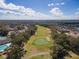 Scenic aerial view of a lush golf course with manicured greens and sand traps, bordered by mature trees and community residences at 1187 Athlone Way, Ormond Beach, FL 32174