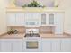 Well-lit kitchen with white cabinets, tile backsplash, and modern electric range at 1187 Athlone Way, Ormond Beach, FL 32174