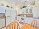 Clean kitchen area featuring white appliances and cabinets, with a breakfast table at 1187 Athlone Way, Ormond Beach, FL 32174