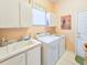 Bright laundry room with a sink, cabinetry, and convenient washer and dryer at 1187 Athlone Way, Ormond Beach, FL 32174