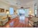 Bright living room featuring hardwood floors, neutral furniture, and view to sunroom at 1187 Athlone Way, Ormond Beach, FL 32174