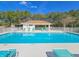 Community pool with clear water, lounge chairs, and covered area at 1187 Athlone Way, Ormond Beach, FL 32174