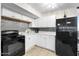 Efficient kitchen featuring white cabinetry, tile backsplash, and black appliances at 2301 S Atlantic Ave # 230, Daytona Beach, FL 32118