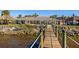 Waterfront backyard with a tropical themed palapa, dock with black post caps, and manicured landscaping at 2912 River Point Dr, Daytona Beach, FL 32118