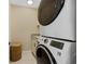 Clean laundry room featuring modern stacked washer and dryer with cabinets and granite counters at 2912 River Point Dr, Daytona Beach, FL 32118