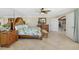 Bright main bedroom featuring tropical bedding, mirrored wall, ceiling fan, and wood furniture at 2912 River Point Dr, Daytona Beach, FL 32118