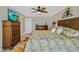 Main bedroom featuring wooden furniture, tropical bedding, ceiling fan, and a flat screen television at 2912 River Point Dr, Daytona Beach, FL 32118