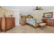 Bright main bedroom featuring tropical bedding, mirrored wall, ceiling fan, and wood furniture at 2912 River Point Dr, Daytona Beach, FL 32118