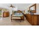 Bright main bedroom featuring tropical bedding, mirrored wall, ceiling fan, and wood furniture at 2912 River Point Dr, Daytona Beach, FL 32118