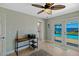 This bright office space features a ceiling fan, sandy decor and a door to the backyard at 2912 River Point Dr, Daytona Beach, FL 32118