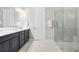 Bathroom featuring double vanity, a glass shower with tile surround and a linen closet at 3257 Bailey Ann Dr, Ormond Beach, FL 32174