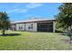 Back of home featuring a yard and enclosed lanai at 3257 Bailey Ann Dr, Ormond Beach, FL 32174