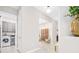 Bright hallway with views of the laundry room and living areas, featuring tile flooring and neutral paint at 3257 Bailey Ann Dr, Ormond Beach, FL 32174