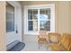 Inviting front porch area, features a cozy seating arrangement with two wooden chairs and a table near a window at 3257 Bailey Ann Dr, Ormond Beach, FL 32174