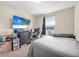 Relaxing bedroom featuring a large TV, a comfortable bed, and a window at 348 Southern Winds Blvd, Deland, FL 32720