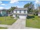 Two-story home featuring a well-manicured lawn, two-car garage and a welcoming green front door at 348 Southern Winds Blvd, Deland, FL 32720