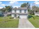 Two-story home featuring a well-manicured lawn, two-car garage and a welcoming green front door at 348 Southern Winds Blvd, Deland, FL 32720