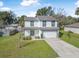 Two-story home featuring a well-manicured lawn, two-car garage and a welcoming green front door at 348 Southern Winds Blvd, Deland, FL 32720