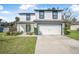 Charming two-story home featuring a manicured lawn and a convenient two-car garage at 348 Southern Winds Blvd, Deland, FL 32720