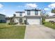 Charming two-story home featuring a manicured lawn and a convenient two-car garage at 348 Southern Winds Blvd, Deland, FL 32720