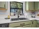 Close-up of a modern kitchen sink with quartz countertops and a view of the backyard at 348 Southern Winds Blvd, Deland, FL 32720