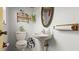 Bright bathroom with a pedestal sink, floral wallpaper, and decorative plants creating a cozy atmosphere at 4 Water Oak Cir, Ormond Beach, FL 32176