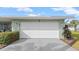Attached two-car garage with a white door, neatly landscaped yard, and partial view of the home's exterior at 4 Water Oak Cir, Ormond Beach, FL 32176