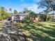 Charming single-story home with well-manicured lawn and mature trees and a circular driveway at 445 John Anderson Dr, Ormond Beach, FL 32176