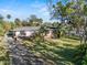 Charming single Gathering home with a front yard surrounded by mature trees and lush landscaping at 445 John Anderson Dr, Ormond Beach, FL 32176