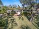 Quaint single Gathering home with a green lawn surrounded by tropical foliage and mature trees at 445 John Anderson Dr, Ormond Beach, FL 32176
