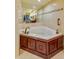 Tiled bathroom featuring a jacuzzi tub with dark wood panels and a view of the double vanity at 4555 S Atlantic Ave # 4508, Port Orange, FL 32127
