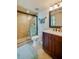 Neutral tiled bathroom with a glass enclosed shower and vanity with dark wood cabinetry at 4555 S Atlantic Ave # 4508, Port Orange, FL 32127