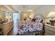 Comfortable bedroom featuring a floral comforter, ceiling fan, and hardwood floors at 4555 S Atlantic Ave # 4508, Port Orange, FL 32127