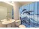 Bathroom with pedestal sink and decorative dolphin shower curtain at 1101 Deer Springs Rd, Port Orange, FL 32129