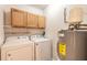 Functional laundry area features washer, dryer, storage cabinets and an energy-efficient water heater at 1101 Deer Springs Rd, Port Orange, FL 32129