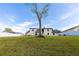 Spacious backyard showing a well-kept lawn, a mature tree, and the rear exterior of the two-story home at 13 Twin River Dr, Ormond Beach, FL 32174