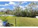 Lush backyard with a green lawn, mature trees, and a white fence, creating a serene outdoor space at 13 Twin River Dr, Ormond Beach, FL 32174