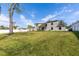 A spacious backyard showcasing a well-maintained lawn, a white fence, and the rear facade of the home at 13 Twin River Dr, Ormond Beach, FL 32174