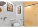 Bright bathroom with a toilet, art work and a walk-in shower with glass door at 13 Twin River Dr, Ormond Beach, FL 32174