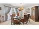 Traditional dining room with a glass table, wood chairs, and an ornate chandelier at 13 Twin River Dr, Ormond Beach, FL 32174