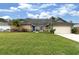 Charming single-story home featuring a stone accent wall, blue door and beautifully landscaped front yard at 13 Twin River Dr, Ormond Beach, FL 32174