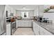 Bright kitchen with stainless steel appliances, white cabinets, ample counter space, and tile flooring at 13 Twin River Dr, Ormond Beach, FL 32174